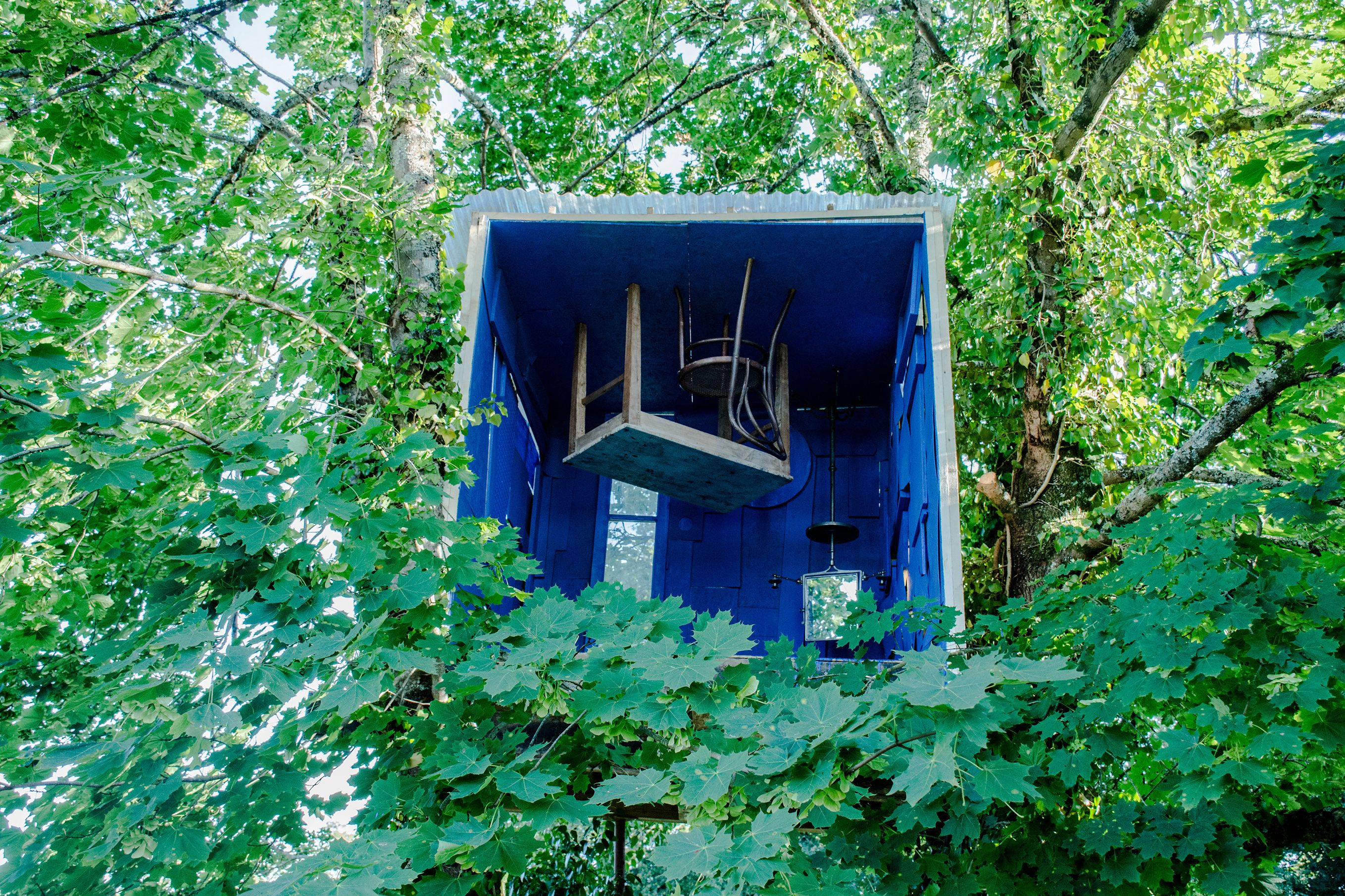 Blaues Baumhaus in grünem Blätterdach